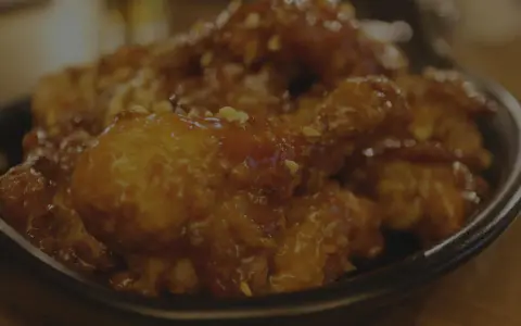 Délicieuse cuisse de poulet au four, nappée d'une sauce sucrée et parsemée de cacahuètes concassées. Un vrai régal !