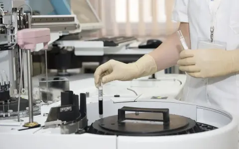 Pracownik w rękawiczkach umieszcza próbkę w automacie analitycznym w laboratoriach Brunel B Co.