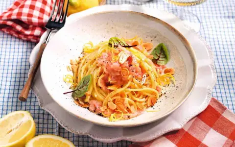 Spaghetti con sughi in bianco, conditi con limone, mandorle e un tocco di rosa.