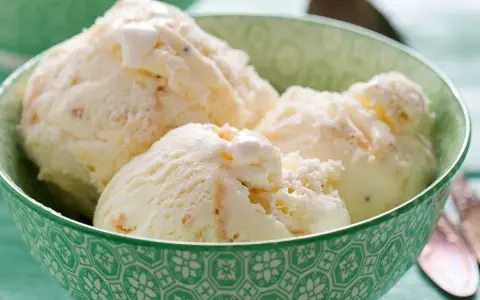 Kremowe lody z mascarpone w zielonej miseczce, idealne na upalny dzień.