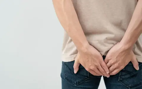 Osoba trzymająca się za pośladki, sugerująca problem z krwią z odbytu. Jaki lekarz może pomóc?