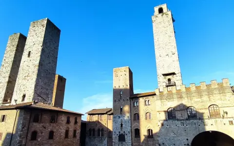 Wieże średniowiecznego miasta San Gimignano wznoszą się dumnie pod błękitnym niebem.