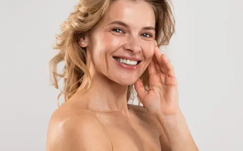 Uśmiechnięta kobieta z blond włosami, która odkrywa swoje naturalne domowe sposoby na zmarszczki.