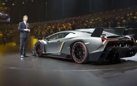 Ein Mann präsentiert den Lamborghini Veneno. Der Lamborghini Veneno Preis ist astronomisch, aber die Exklusivität rechtfertigt ihn.