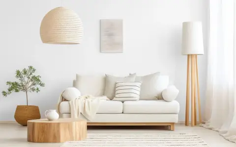 Jasny salon, gdzie kolor biały oznacza spokój i czystość. Sofa, lampa i zasłony tworzą harmonijną całość.