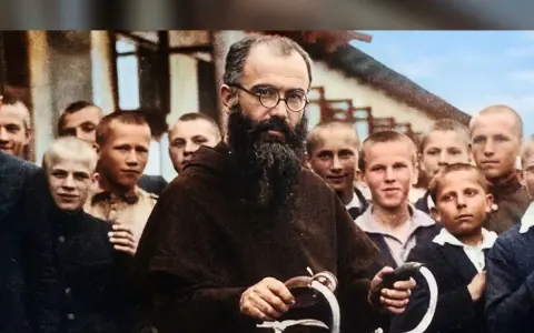 Święty Maksymilian Kolbe w otoczeniu chłopców, z charakterystyczną brodą i okularami, trzymający fragment roweru.