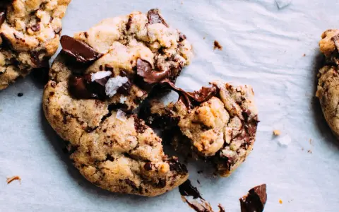 Des cookies aux pépites de chocolat fondantes, parfaits pour apprendre comment faire des cookies maison. Le chocolat coule, invitant à la dégustation.