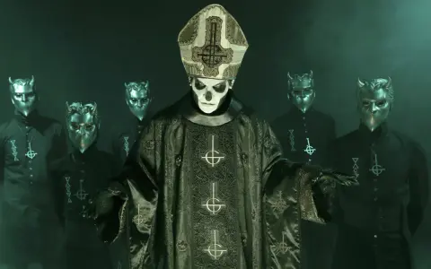Papa Emeritus IV, klädd i en detaljerad mörkgrön prästrock med korsmotiv, står framför en grupp maskerade följeslagare med horn.