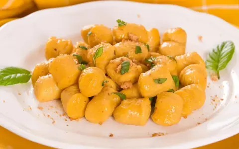 Kopytka z dyni wg Gesslerowej, delikatne i aromatyczne, posypane świeżą bazylią i okruszkami.