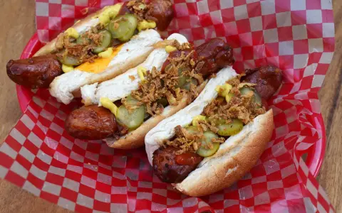 Heißer Hot Dog aus dem Airfryer, belegt mit Gurken, Zwiebeln und Senf. Perfekt für einen schnellen Snack!