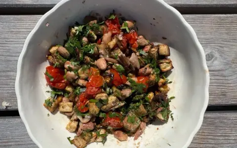 Bunter Gemüsesalat mit Auberginen, Tomaten und Bohnen, garniert mit Petersilie. Ein gesundes Gericht, inspiriert von TCM-Rezepten.