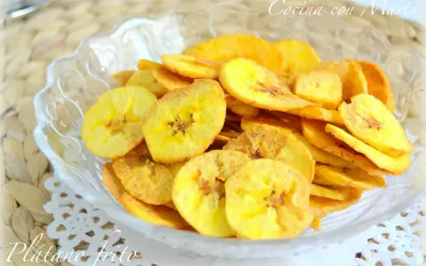 Crujientes rodajas de plátano frito en un cuenco de cristal. Un delicioso snack casero.