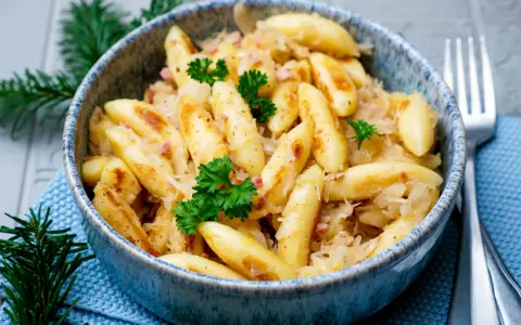 Herzhafte Schupfnudeln mit Sauerkraut, garniert mit Petersilie. Ein Klassiker, der auf keinem Tisch fehlen darf.