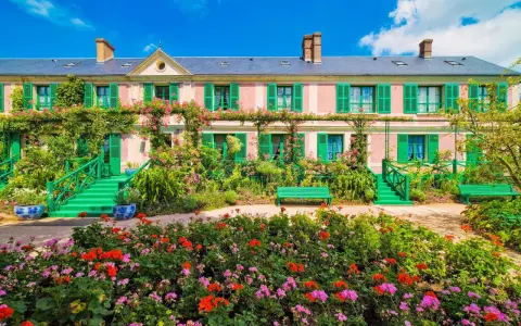 La maison rose de Monet à Giverny, entourée de fleurs éclatantes et de verdure luxuriante. Idéal pour savoir que faire autour de Giverny.