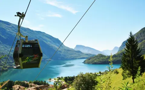 Cabina panoramica sul lago di Molveno, con montagne sullo sfondo. Si intravede una cascata tra gli alberi.