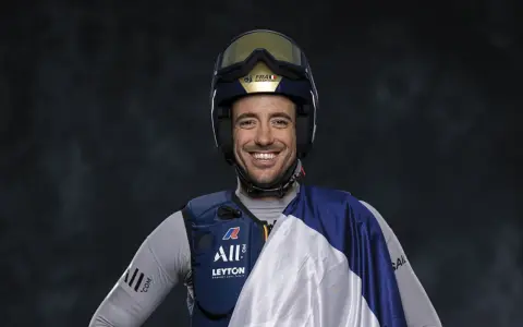 Quentin Delapierre, souriant, porte un casque de voile et une tenue de sport.