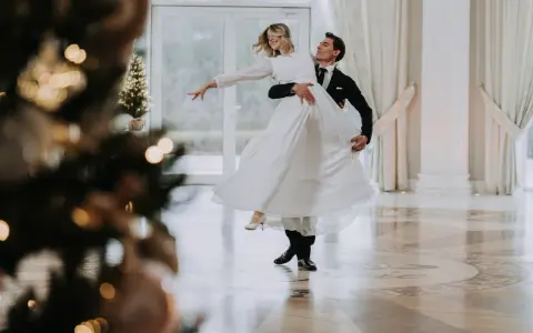 Para pierwszy taniec bez stresu, kursy online czy szkoła tańca? Młoda para w eleganckich strojach wiruje na parkiecie, tworząc romantyczną atmosferę.