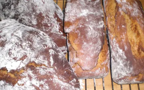 Nybakade sirapslimpor, pudrade med mjöl, redo att avnjutas. Ett perfekt sirapslimpa recept för hembakat bröd.