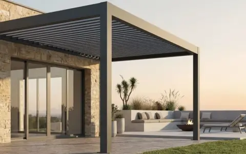 Una moderna casa con una **pérgola bioclimática** que ofrece un espacio exterior acogedor con asientos, tumbonas y una hoguera.