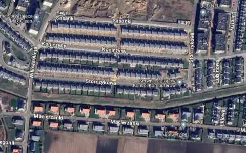 Widok z lotu ptaka na osiedle łanowe z rzędami domów szeregowych i jednorodzinnych, ulicami Sasanki, Koniczyny, Macierzanki i Storczykowa.