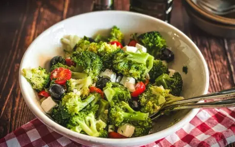 Frischer Brokkolisalat mit Kirschtomaten, schwarzen Oliven und Feta. Perfekt für gesunde Brokkoli Rezepte.