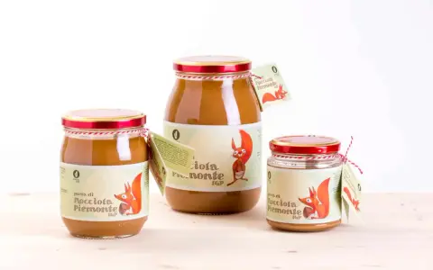 Tre barattoli di pasta di nocciola Piemonte IGP, con etichette raffiguranti uno scoiattolo.