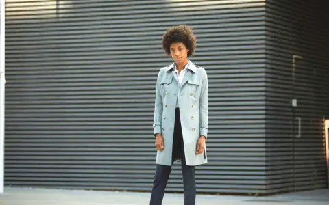 Mujer con un trench ligero y elegante, lista para enfrentar el día con estilo.