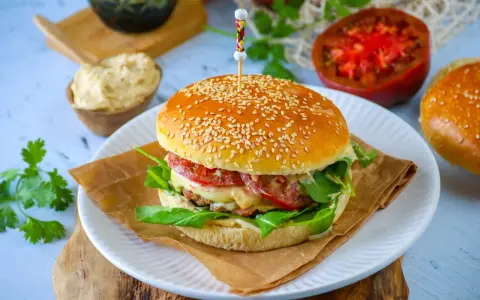 Un délicieux pain burger maison garni de légumes frais, de fromage fondant et d'une viande savoureuse. Un régal pour les yeux et les papilles !