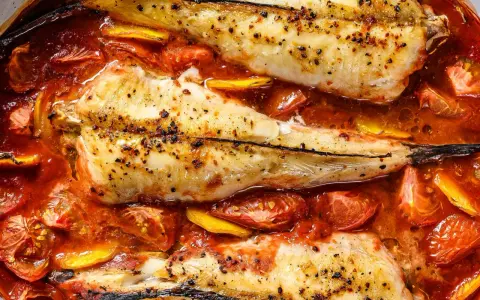 Colas de rape al horno, tiernas y jugosas, nadando en una salsa de tomate y limón. Un plato delicioso y fácil de preparar.