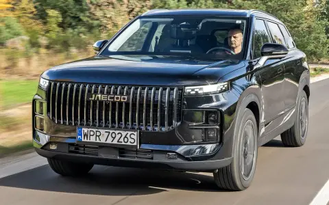Czarny Jaecoo 7 w ruchu, z kierowcą za kierownicą. Sprawdź aktualną jaecoo 7 cena i dowiedz się więcej o tym SUV-ie.