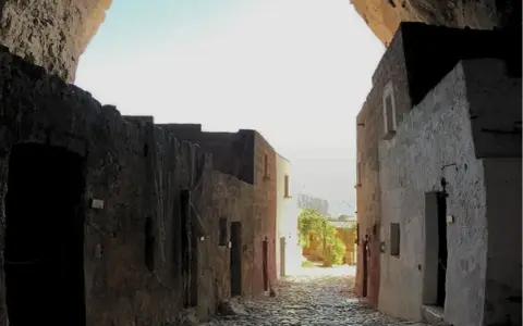 Antica via acciottolata che conduce verso il mare, incastonata nella roccia della grotta Mangiapan.