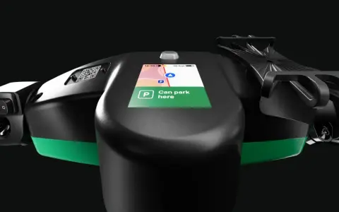 Lenkrad eines E-Scooters mit Display, das die Bolt Taxi App anzeigt. "Can park here" ist auf dem Bildschirm zu lesen.