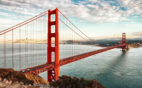 El icónico puente Golden Gate, con su distintivo color naranja, se extiende sobre el agua. ¿Cuánto mide el puente de San Francisco? Es una maravilla de la ingeniería.