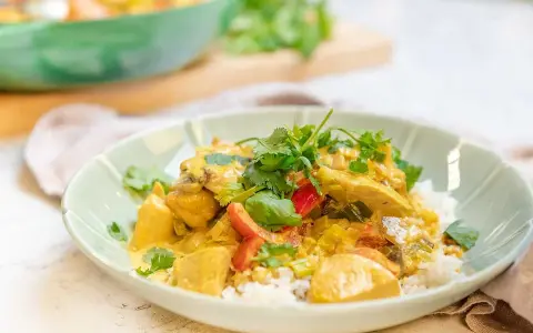 En krämig kyckling curry med ris, toppad med färsk koriander. En härlig och smakrik rätt.