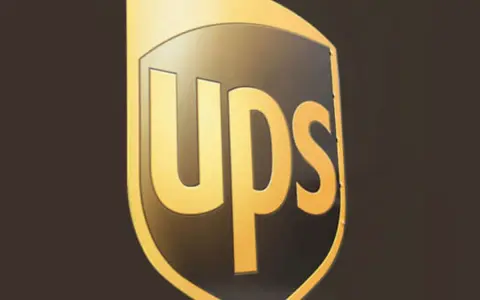Logo UPS dorato su sfondo scuro. Informazioni sullo stipendio corriere UPS.