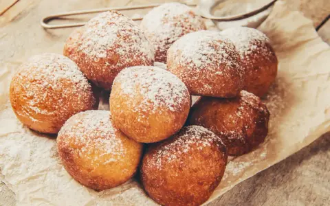 Délicieux beignets saupoudrés de sucre glace, rappelant la recette pâte à beignets de grand-mère. Un délice croustillant et moelleux.
