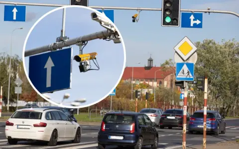 Widok na skrzyżowanie z sygnalizacją świetlną i znakami drogowymi. W powiększeniu widać kamery rejestrujące przejazd na czerwonym świetle.