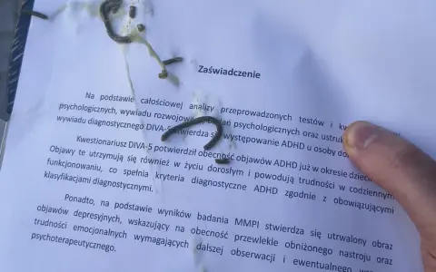Na zaświadczeniu o ADHD, obok tekstu, widać ślady czegoś, co może przypominać trudności w pisaniu, jak przy dysgrafii.