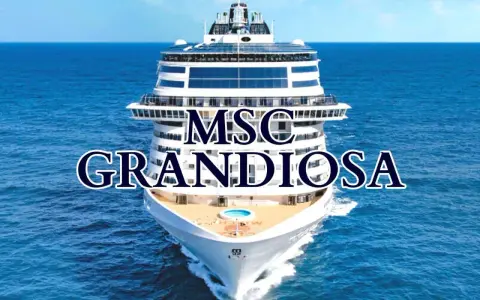 La MSC Grandiosa solca il mare blu, un gigante bianco con ponti che promettono avventure.