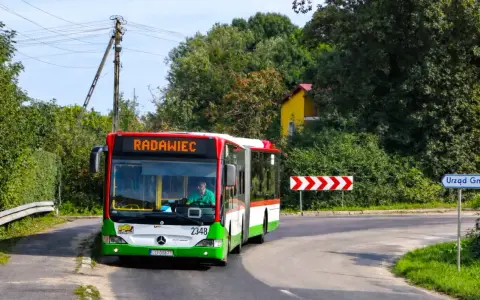 Autobus linii 43 jedzie do Radawca. Na drodze znak "Urząd Gminy".