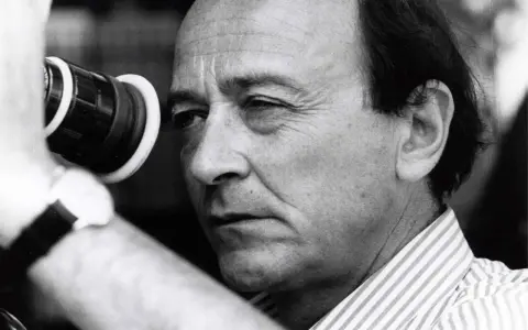 Regista con cinepresa, pronto a catturare storie per un **free cinema** che parla a tutti.
