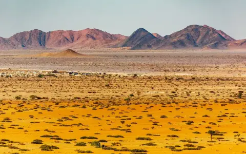 Pustynny krajobraz Namibii z górami w tle. Idealny czas na podróż do Namibii to okres od maja do października, kiedy jest sucho i chłodniej.