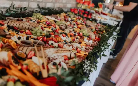 Stół pełen smakołyków na poprawiny: sery, wędliny, owoce, pieczywo i dipy. Idealna uczta po weselu.
