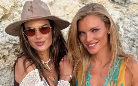 Alessandra Ambrosio y una amiga sonríen a la cámara, luciendo gafas de sol y joyas veraniegas.