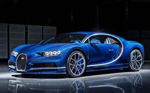 Niebieski Bugatti Chiron błyszczy w studio, jego aerodynamiczna linia podkreślona białym akcentem.