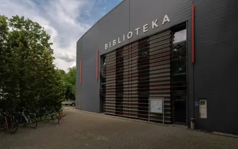 Nowoczesna biblioteka na terenie Akademii Ignatianum w Krakowie. Obok stoją rowery.