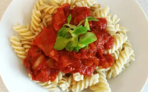 Fusilli z bogatym sosem passata pomidorowa, ozdobione świeżą zieleniną. Pyszne danie, które zadowoli każdego miłośnika włoskich smaków.