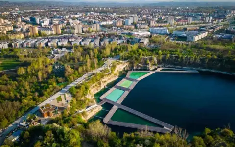 Widok na zakrzówek kapielisko z basenami w kamieniołomie, otoczone zielenią i zabudową miejską.
