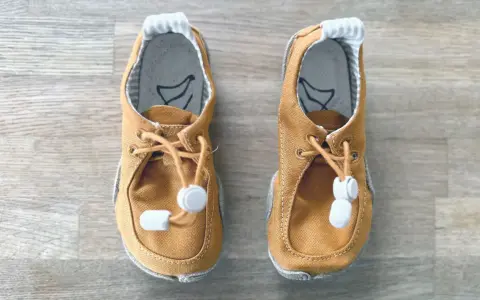 Braune Lauflernschuhe mit Schnürung und Gummizug. Ideal für die ersten Schritte, ab wann sie gebraucht werden, hängt vom Kind ab.