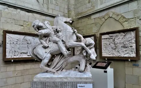 Sculpture équestre de David d'Angers, un homme en uniforme militaire sur un cheval cabré, avec des bas-reliefs en arrière-plan.